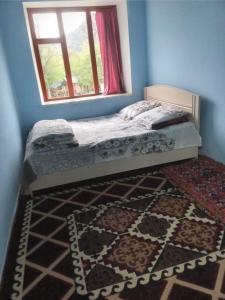 - une chambre avec un lit, une fenêtre et un tapis dans l'établissement Бакай 1, à Arkit