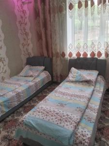 2 aparte bedden in een kamer met een raam bij Бакай 1 in Arkit