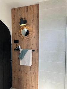 een badkamer met een houten wand met een spiegel en een handdoekenrek bij Rembrandts Beach Suite in Zandvoort