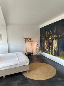 een slaapkamer met een bed en een schilderij aan de muur bij Rembrandts Beach Suite in Zandvoort
