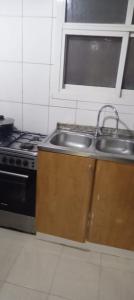 a kitchen with a sink and a stove at My Home Stay apartment 2 in Abu Dhabi