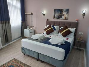 um quarto com uma cama grande e almofadas em Emirhan Inn Hotel & Suites em Istambul