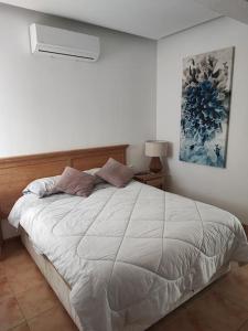ein Schlafzimmer mit einem großen weißen Bett in einem Zimmer in der Unterkunft Apartamento grande Bambú, Cala Montgó in L'Escala