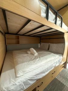 ein Etagenbett mit weißer Bettwäsche und Kissen darauf in der Unterkunft The Room @ Bugis in Singapur