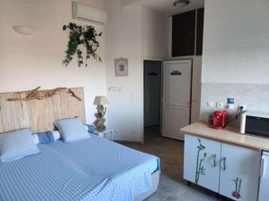 1 dormitorio con 1 cama y cocina con nevera en Casalta en Folelli