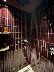 ビアリッツにあるホテル ドゥ シルエットの黒いタイル張りの壁のバスルーム(シャワー付)