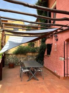 a patio with a table and chairs under a white canopy at Grotta dell'edera in Finale Ligure