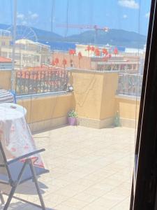 una silla en el balcón con vistas a la playa en B&B Su Canistreddu, en Alghero