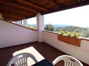 a balcony with chairs and a view of the ocean at Comino Alto Agriturismo e Appartamenti in Capo Comino