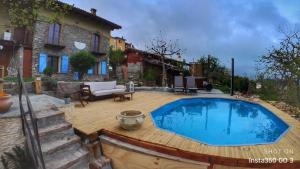 a swimming pool on a wooden deck next to a house at B&B La casa dei cuori in Millesimo