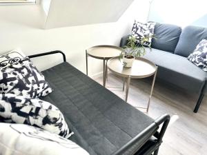 a living room with a couch and two tables at Palace Quarter 2 Peaceful Modern Central Top Floor Apartment in Budapest