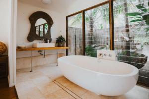 a bathroom with a large white tub and a window at The Boathouses at Leaves & Fishes in Lovedale