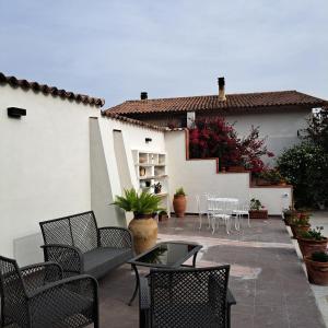 a patio with chairs and tables and a building at Casa Gelsomino in Carlentini