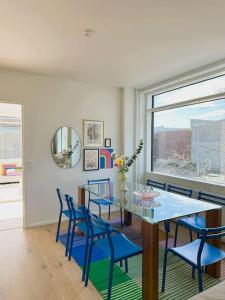 ein Esszimmer mit einem Tisch und blauen Stühlen in der Unterkunft New luxury 110sqm apartment with terrace and great location in Helsinki