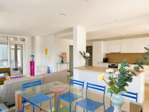 ein Wohnzimmer mit einem Glastisch und blauen Stühlen in der Unterkunft New luxury 110sqm apartment with terrace and great location in Helsinki