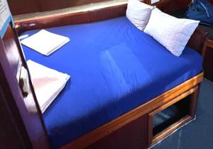 a small bed with blue sheets and pillows on a boat at Beforelunch Cruise in Fethiye
