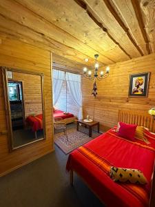 a bedroom with a red bed in a log cabin at Rakši in Cēsis