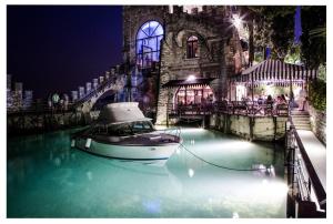 a boat in the water in front of a building at Hotel Villa Fiordaliso in Gardone Riviera