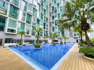 a swimming pool in a building with palm trees at 2bedroom soho suites klcc in Kuala Lumpur