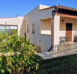 a white house with a table and chairs on a lawn at Villa Azzurra in Lampedusa