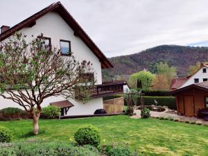 a large white house with a grass yard at Ferienwohnung Edersonne in Hemfurth-Edersee