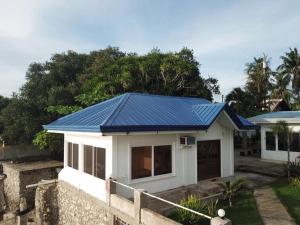 une maison avec un toit bleu métallique dans l'établissement Mariana Guesthouse 1 in Panagsama Beach, à Moalboal