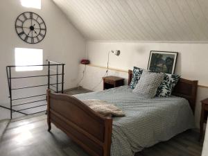 a bedroom with a bed and a clock on the wall at La Lauseta in Saint-Julien