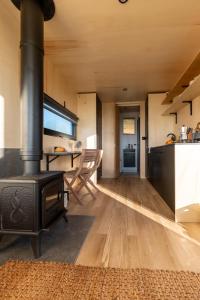 a living room with a stove and a table at OffGrid Tiny Home W/ View Of South Downs NP in Petersfield
