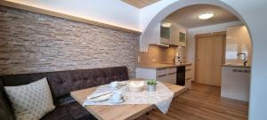 a dining room with a table and a brick wall at Haus Kirchmaier in Pertisau