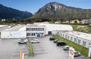 ein großes Gebäude mit Autos auf einem Parkplatz in der Unterkunft Sporthotel Ferlach in Ferlach