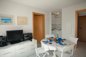 uma sala de jantar com uma mesa branca e uma televisão em Terrace Sur Menton - Happy Rentals em Menton