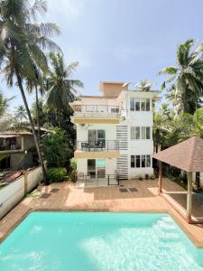 a house with a swimming pool in front of a house at Rainforest Enclave, Arpora - 10 mins to Baga beach in Arpora