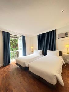 Кровать или кровати в номере The Henry Suites MiraNila Quezon City