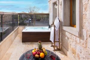 a balcony with a tub and a table with fruit at Cappadocia Pegasos Cave Suite Hotel in Uçhisar