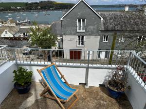 una silla azul sentada en un balcón con una casa en Falmouth View, en Falmouth