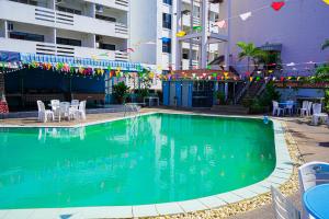 a swimming pool with chairs and tables and a building at Marine paradise Encore in Pattaya South