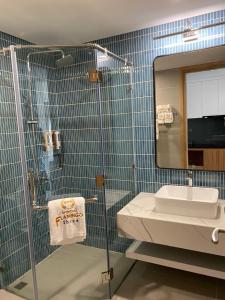 ein Bad mit einer Dusche, einem Waschbecken und einem Spiegel in der Unterkunft Flamingo Hải Tiến in Thanh Hóa