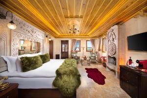 a bedroom with a large white bed with a gold ceiling at Cappadocia Pegasos Cave Suite Hotel in Uçhisar