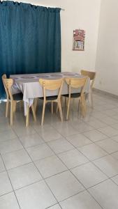 LabuにあるBahanis Homestay Suci Bandar Ainsdale, Serembanのテーブル(椅子2脚付)と青いカーテン