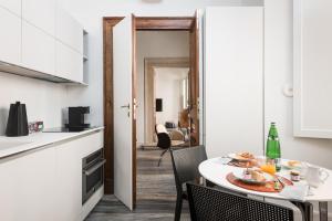 a kitchen and dining room with a table and chairs at Palazzo Delle Pietre - Luxury Apartments in Rome