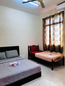 1 dormitorio con 2 camas y ventana en Dhiaa Homestay D Jembal, en Kuala Terengganu