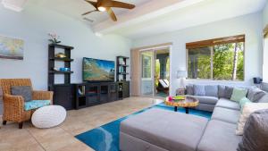 a living room with a couch and a tv at HAWAIIANA ESCAPE Tropical 3BR Kulalani Home with Bikes and Beach Club in Waikoloa