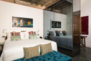 una camera con un letto bianco e un divano blu di Palazzo Delle Pietre - Luxury Apartments a Roma
