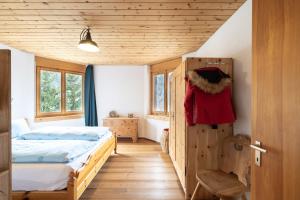 a bedroom with a bed and a wooden ceiling at Chasa Serras Kuemin in Scuol