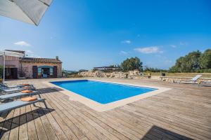 a swimming pool on a wooden deck with lounge chairs at Finca Puig Blanc by Sealand Villas in Muro