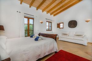 a white bedroom with a bed and a couch at Finca Puig Blanc by Sealand Villas in Muro +20 photos