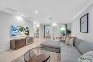 a living room with a couch and a tv at Private neighborhood Heated Pool Lush Surroundings Harbor Key RESlDENCES in Fort Lauderdale