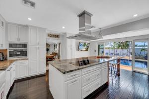 a kitchen with white cabinets and a large island at Private neighborhood Heated Pool Lush Surroundings Harbor Key RESlDENCES in Fort Lauderdale