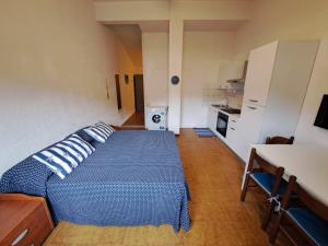 a bedroom with a blue bed and a kitchen at Casa Viola in Campese +10 photos