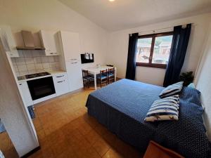 a bedroom with a bed and a kitchen with a table at Casa Viola in Campese